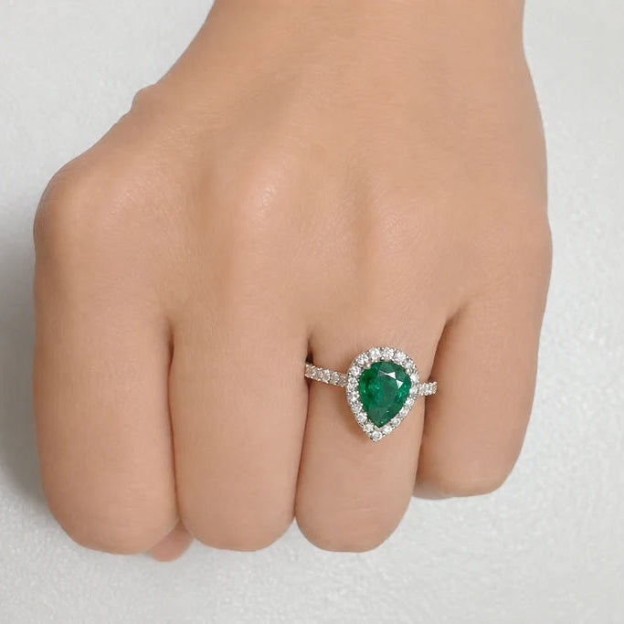 18k white gold ring with a pear-shaped GIA emerald and diamond pave surround