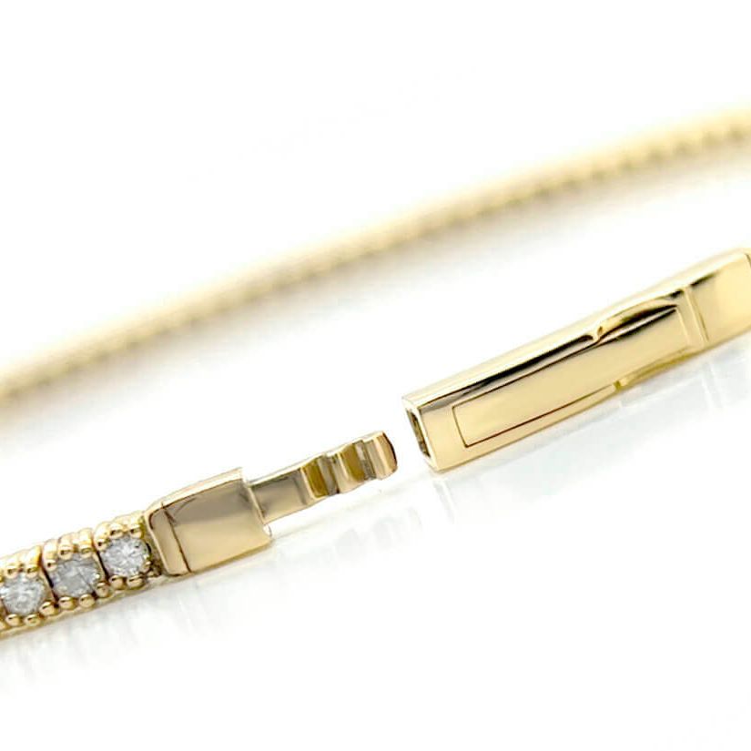 rigid 14k white gold tennis bangle bracelet with round diamonds encircling the band