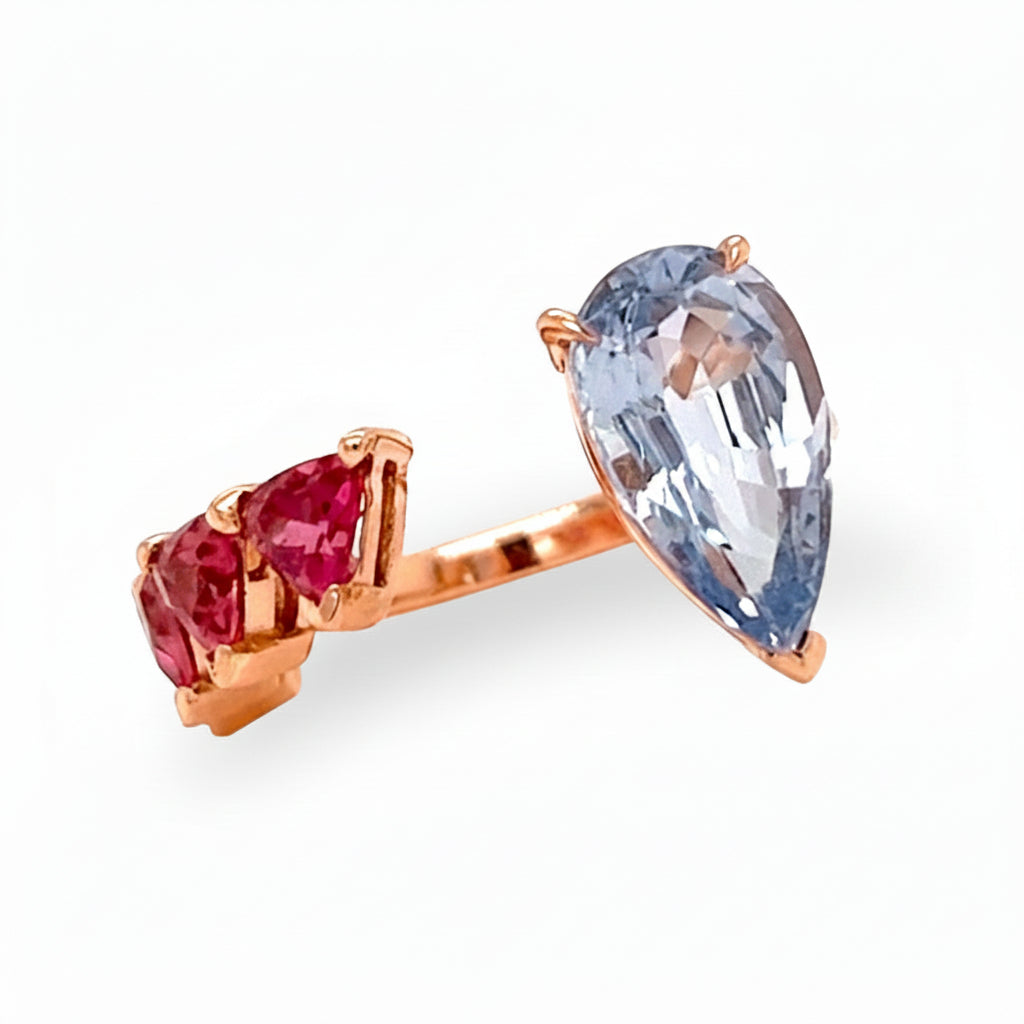 18k gold ring with pear sapphire and trillion-cut rubellite in a bypass design