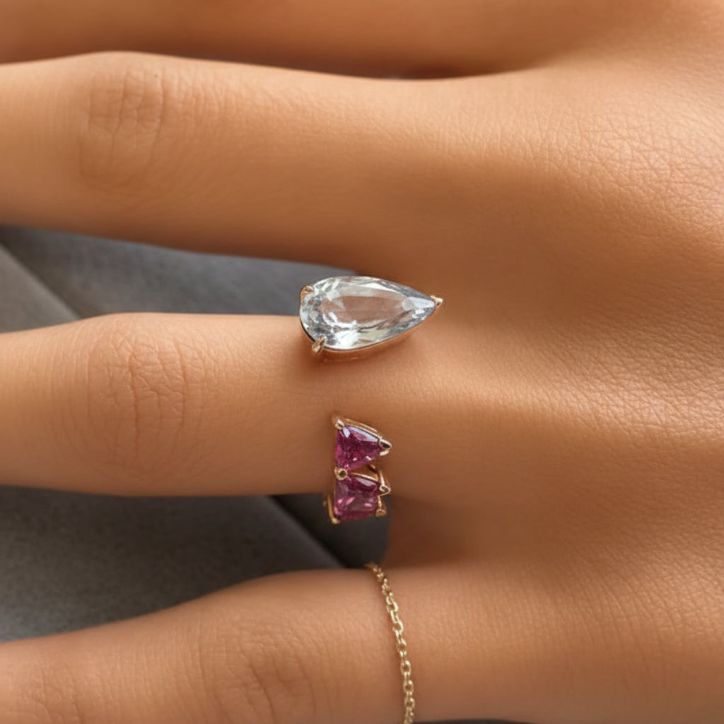 18k gold ring with pear sapphire and trillion-cut rubellite in a bypass design
