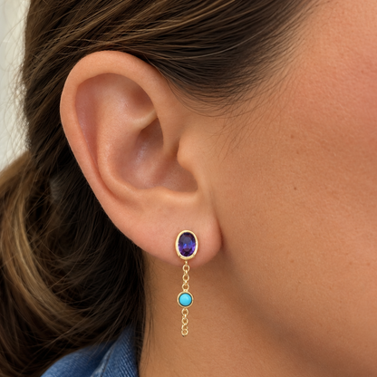 Close-up of amethyst and turquoise star studs in 14k yellow gold with double chain detail