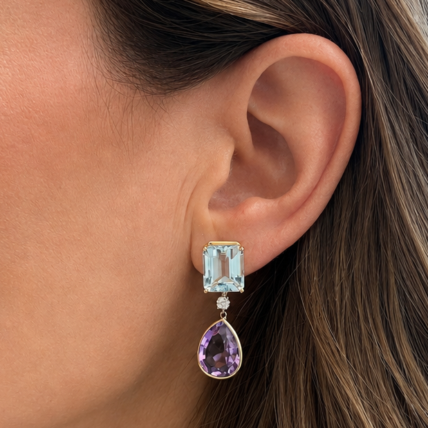 close up of aquamarine and amethyst drop earrings in 14k yellow gold