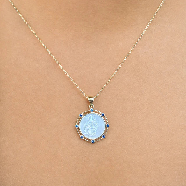 14k gold pendant with mother-of-pearl center and sapphire halo