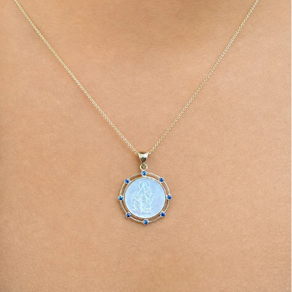 14k gold pendant with mother-of-pearl center and sapphire halo