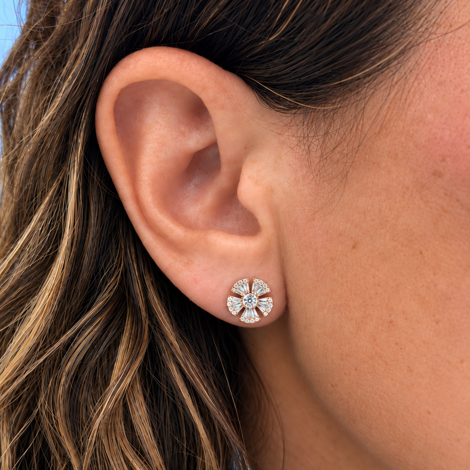 Detail of baguette and round diamonds across the petals of an 18k rose gold stud