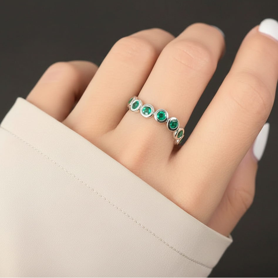 18k white gold ring with bezel-set round emeralds totaling 0.95 carats