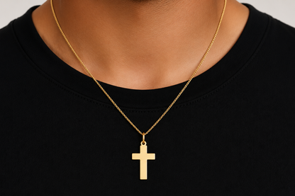 plain gold cross pendant worn on a chain, detail view
