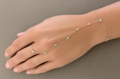 bezel set diamond hand chain bracelet in 14k gold, worn on the hand