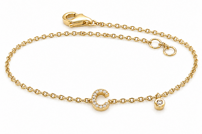 14kt gold initial bracelet with bezel-set diamond accent worn on wrist