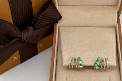 emerald and diamond stud earrings on the ear, close up