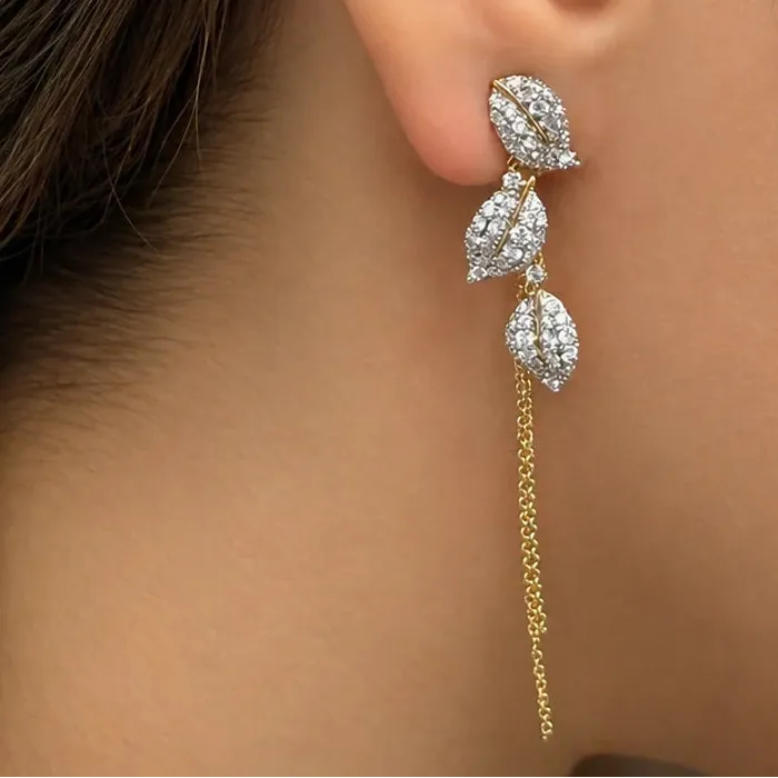 Leaf-shape drop earrings in 18k yellow gold with diamond pavé and long chain by Diamond Tales