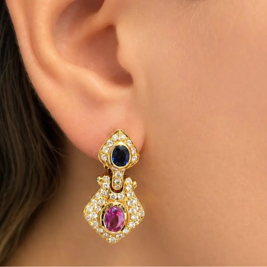 18k gold earrings with sapphire centers in a halo of diamond accents