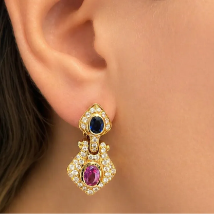 18k gold earrings with sapphire centers in a halo of diamond accents