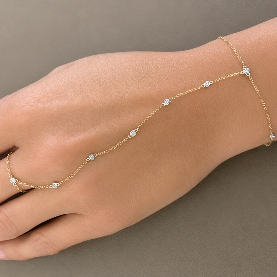 bezel set diamond hand chain bracelet in 14k gold, worn on the hand