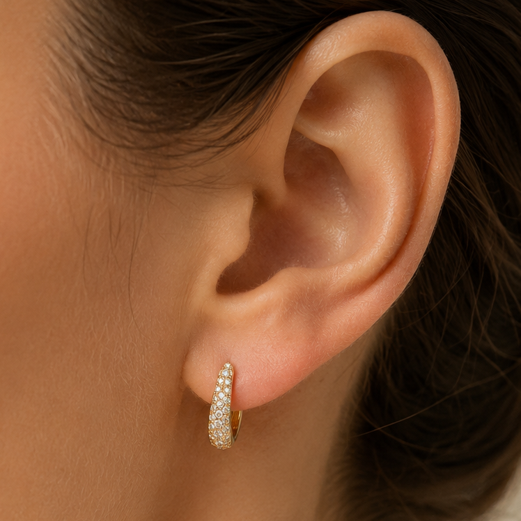 Pave diamond mini hoops in 14k gold shown on the ear