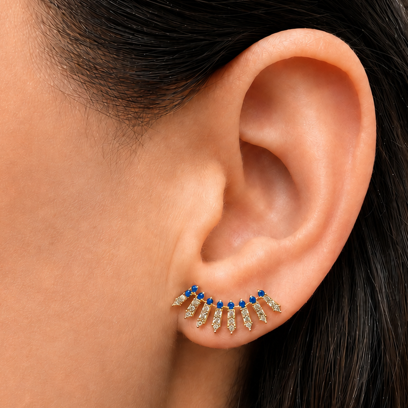 14k yellow gold ear crawlers with 46 diamonds and 18 round blue sapphires, angled view