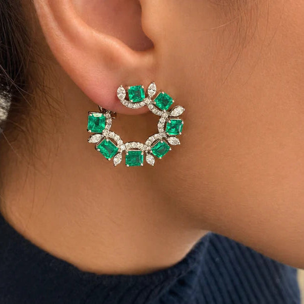 18k white gold earrings with pear emerald drops and marquise diamond accents in an arc design