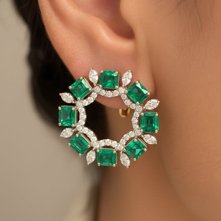 18k white gold earrings with pear emerald drops and marquise diamond accents in an arc design