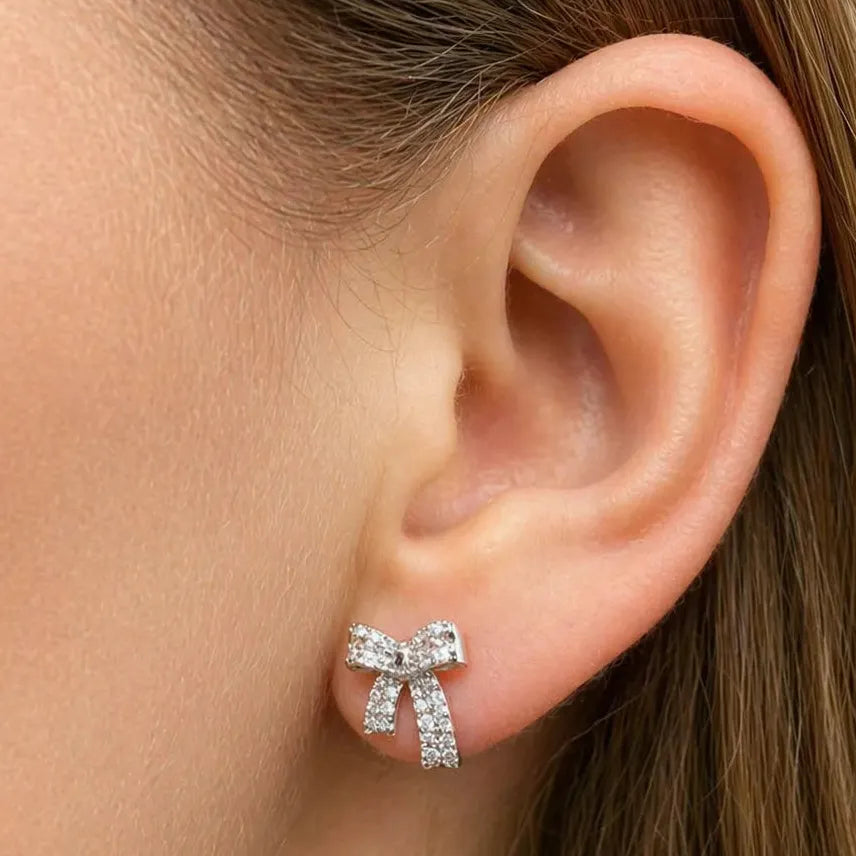 18k white gold bow stud earrings with diamond accents totaling 0.34 cts