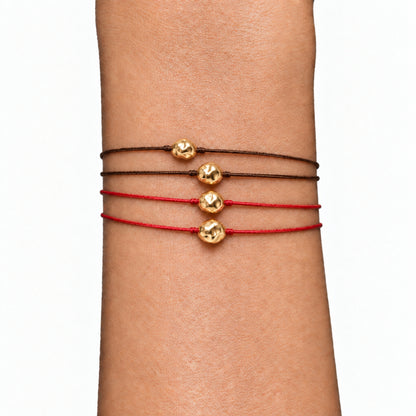 Gold nugget macramé cord bracelets stacked on the wrist