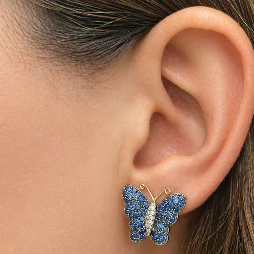 18k white and yellow gold butterfly stud earrings set with pavé blue sapphires and diamond accents