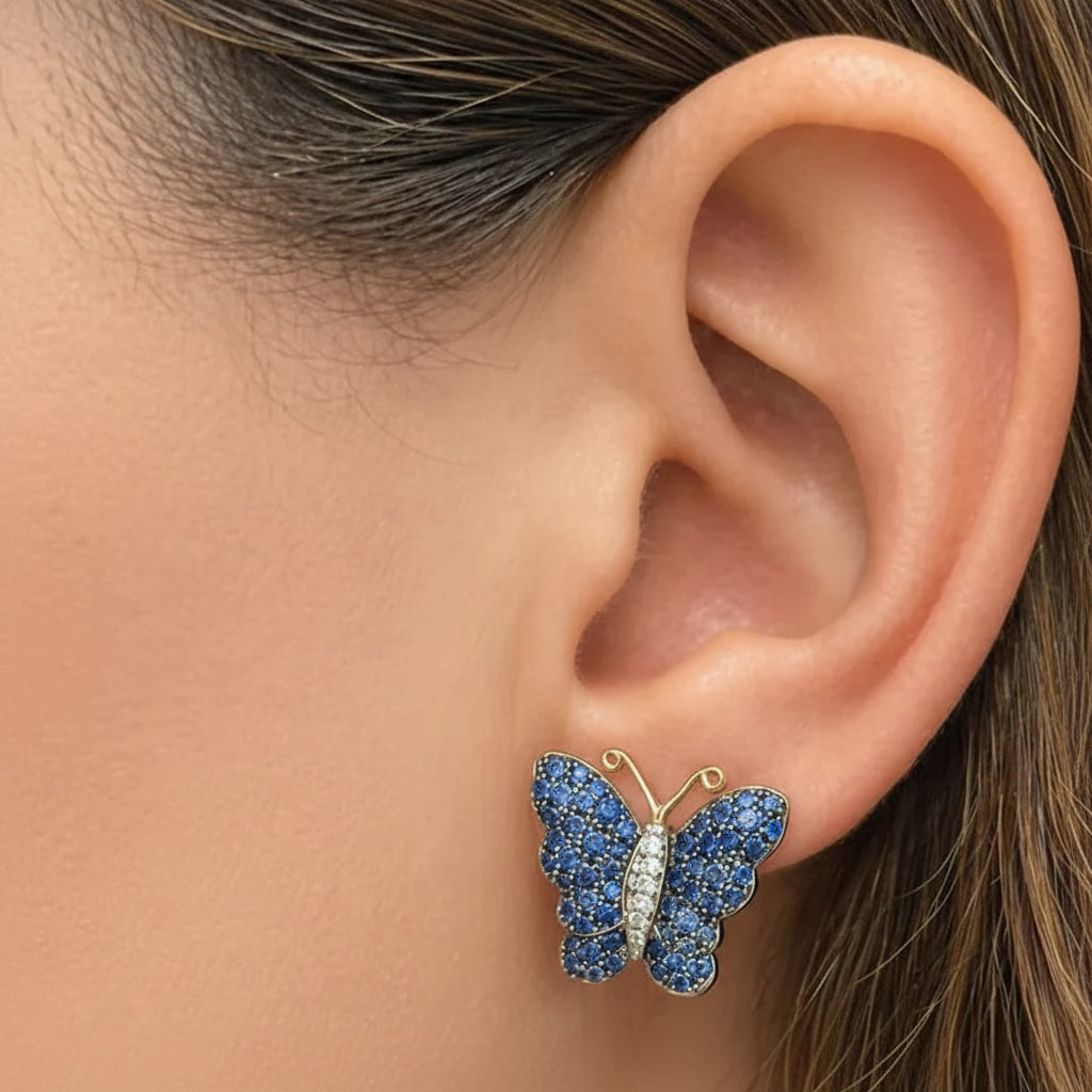 18k white and yellow gold butterfly stud earrings set with pavé blue sapphires and diamond accents