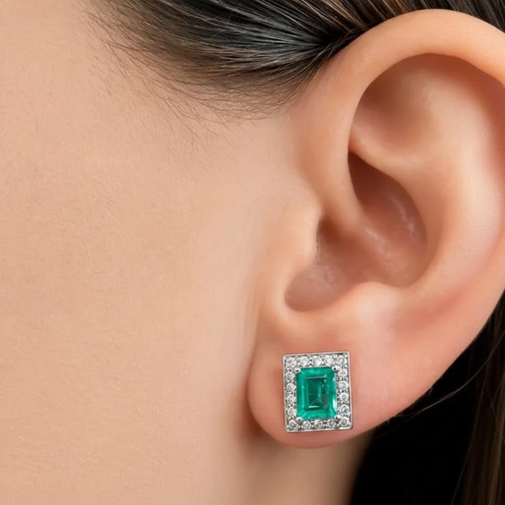 18k white gold stud earrings featuring natural Colombian emeralds and diamond accents