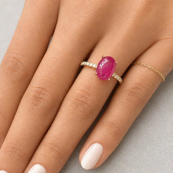 18k yellow gold band featuring an oval ruby cabochon and round diamond accents