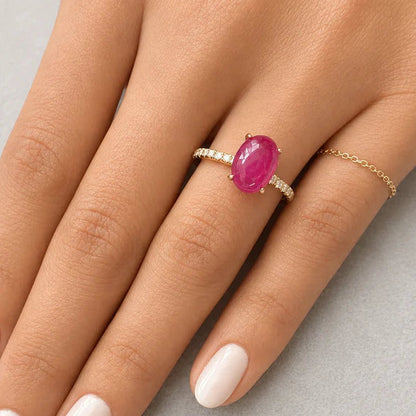 18k yellow gold band featuring an oval ruby cabochon and round diamond accents