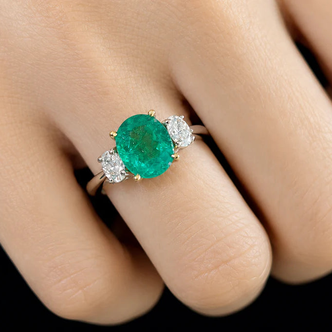18k gold ring with oval emerald and oval diamond side stones