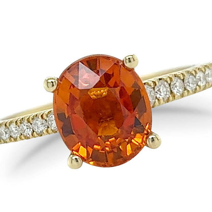 18k yellow gold ring with oval mandarin garnet center and diamond halo with pave shank