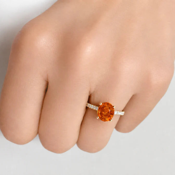 18k yellow gold ring with oval mandarin garnet center and diamond halo with pave shank