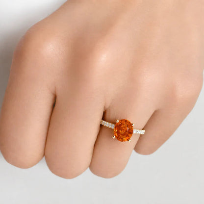 18k yellow gold ring with oval mandarin garnet center and diamond halo with pave shank