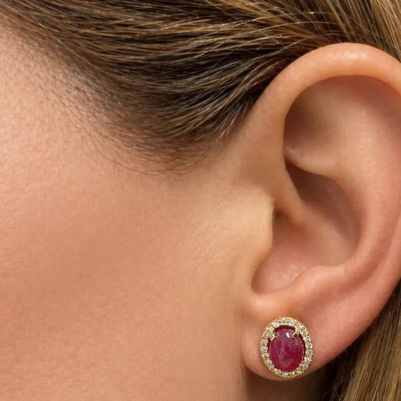 18k yellow gold stud earrings featuring oval ruby cabochons surrounded by diamond halos