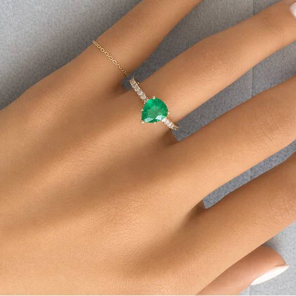 18k yellow gold pear emerald ring with round brilliant diamonds by Diamond Tales