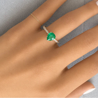18k yellow gold pear emerald ring with round brilliant diamonds by Diamond Tales