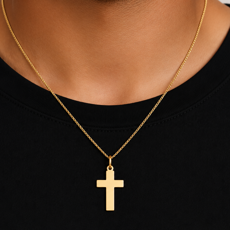 plain gold cross pendant worn on a chain, detail view