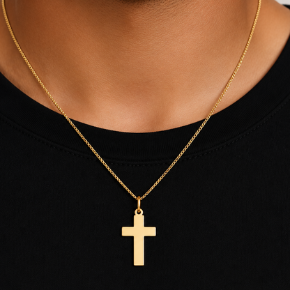 plain gold cross pendant worn on a chain, detail view