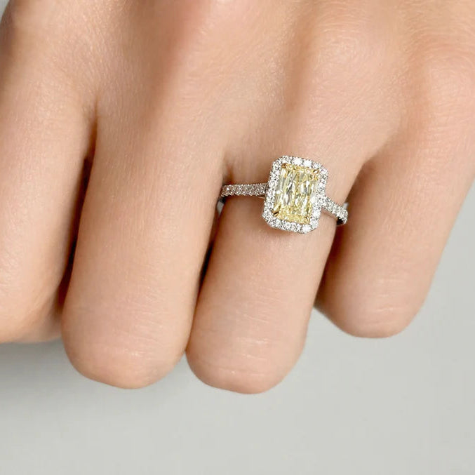 Platinum ring with a radiant‑cut fancy yellow diamond and split shank diamond pave
