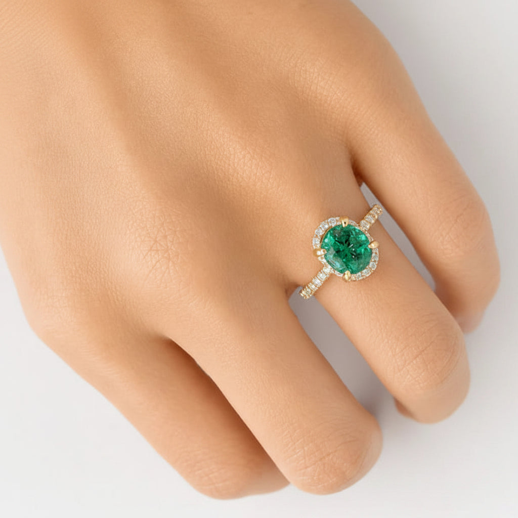 18k yellow gold ring with a round emerald center and surrounding diamonds