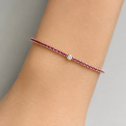 18k yellow gold tennis bracelet with red ruby links and a central diamond detail