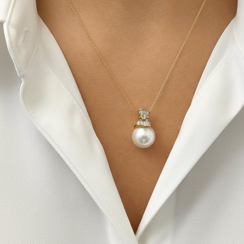 18k gold necklace with a 13.5 mm South Sea pearl, 13 tapered-baguette diamonds totaling 0.38 carats, and one 0.05 carat marquise diamond