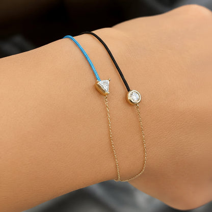 18k gold chain and silk cord bracelet with trillion-cut diamond centerpiece